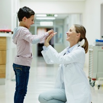 Female doctor and child paint giving high fives