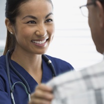 Female nurse smiling at a male patient