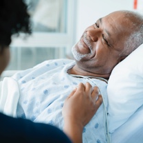 Man lying in hospital bed and smiling