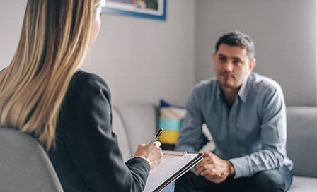 Young man, alcoholic, talking to female therapist about his problems, on  therapy session