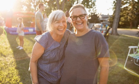 Two women smiling at the camera. 