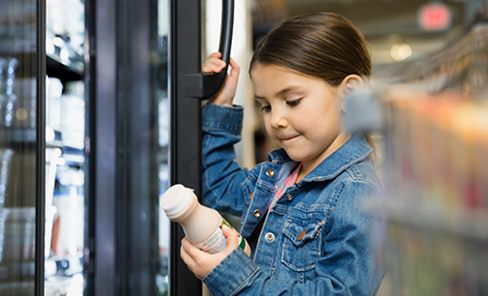 Young girl looking at a bottle of chocolate milk