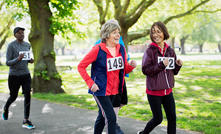 Active senior women friends power walking sports race in park